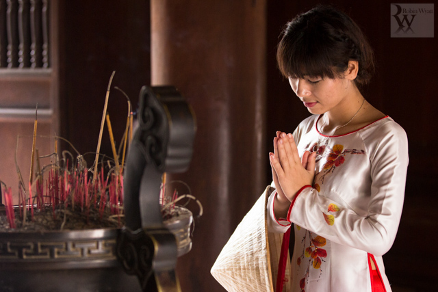 A young Vietnamese student offers prayers for success in her studies at Hanoi’s Temple of Literature.