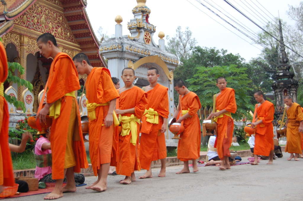 Luang Prabang Buddhist monks collecting alms on street, Laos.