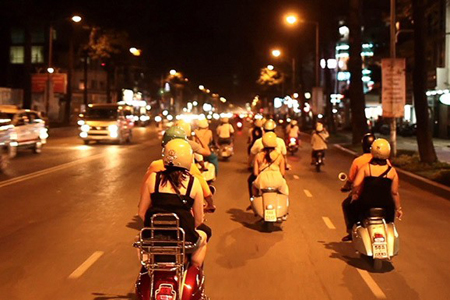 Along the hustling and bustling streets of saigon at Night on the back of Vespa