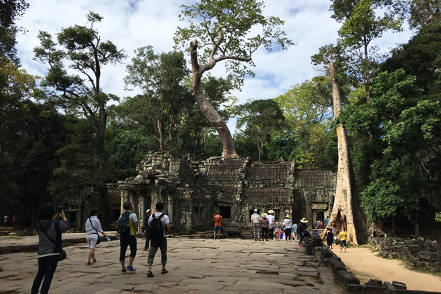 The entrance of Ta Prohm Temple where we can see the ancient banyan trees roots on the roof of ruined temples