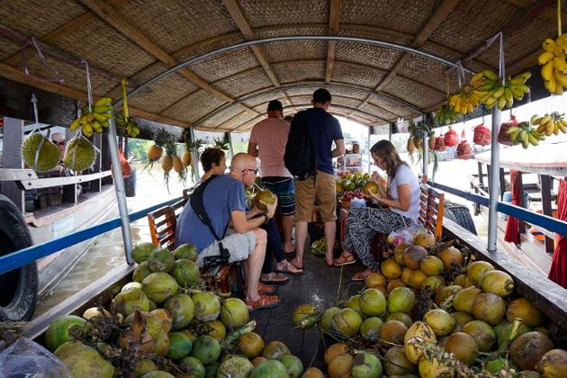 enjoy coconut juice at cai be floating market