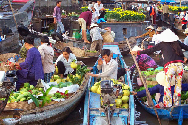 Local boats exchanging fruit and vegetable in Cai Be floating market