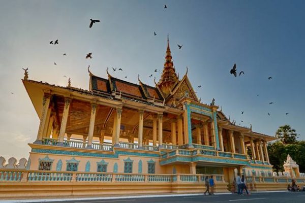 Peaceful birds fly over Royal Palace in Phnom Penh