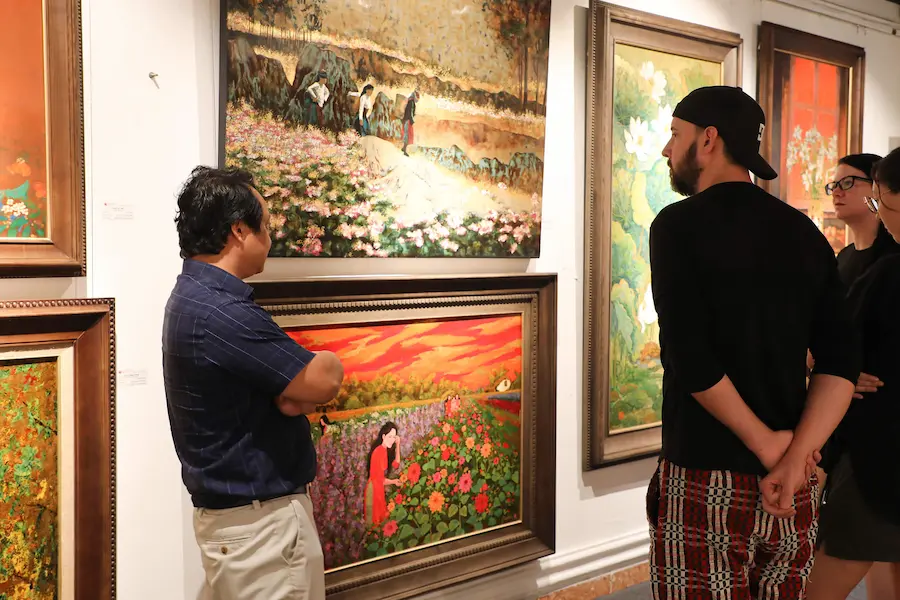 conversation with local art collector during vietnam vacation packages