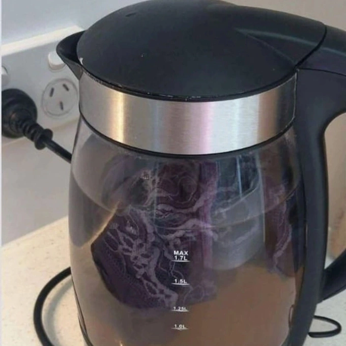 a tourist using electric kettle to wash clothes